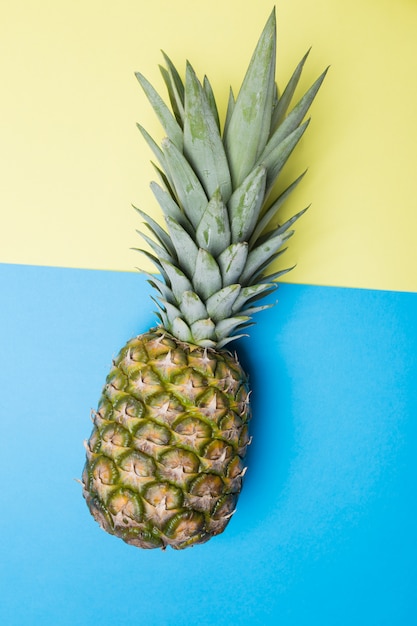 Ripe pineapple on a blue and yellow background