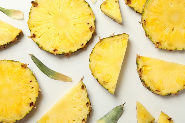 Ripe pineapple slices on white background, top view