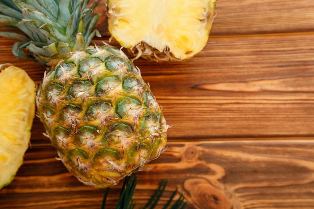 Ripe Pineapple Tropical summer fruit pineapple sliced and whole pineapple on a wooden brown dark table Flat lay with copy space High quality stock photo