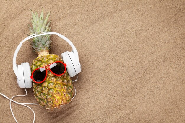 Ripe pineapple with sunglasses and headphones