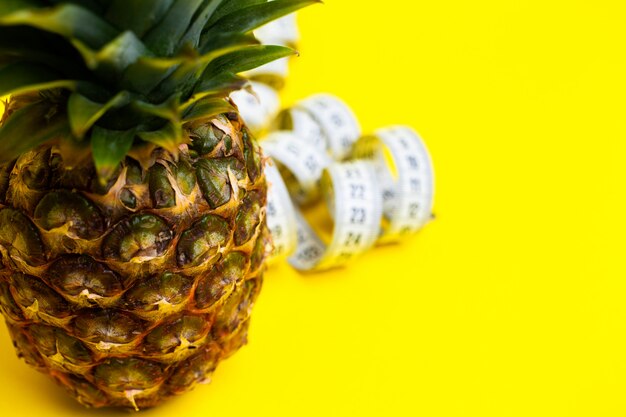 Ripe pineapple with tape measure