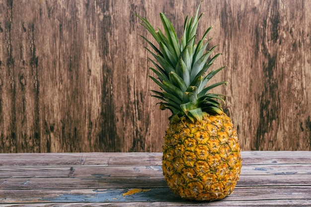 Ripe pineapple on wooden table Ripe fruit with wood background