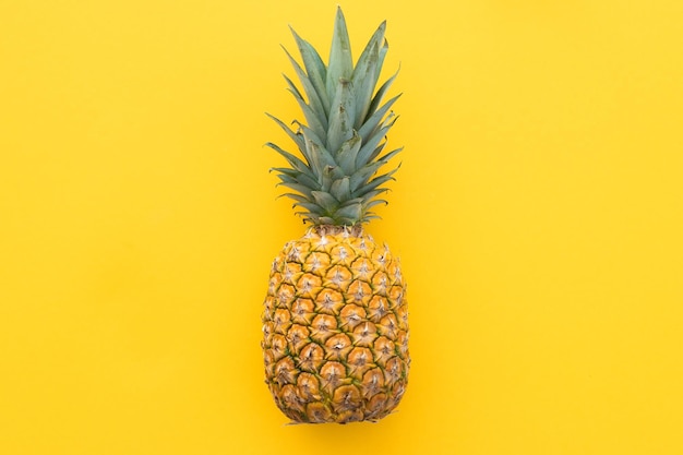 Ripe pineapple on a yellow background