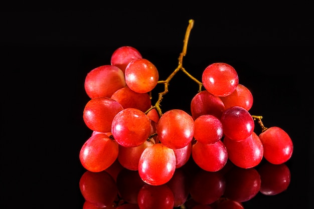 ripe pink grapes on black background