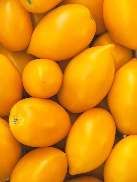 Ripe plum yellow tomatoes as a background closeup