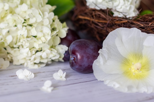 Ripe plums in a vine basket on a wooden background