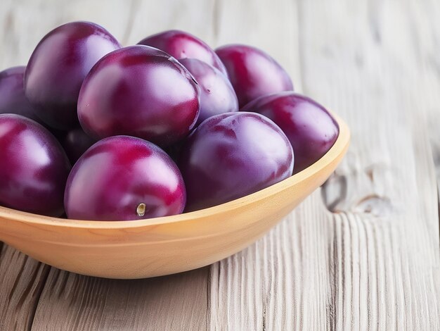 Ripe plums in a wooden bowl on a light background