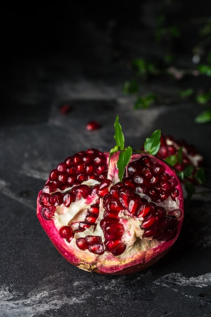 Ripe pomegranate fruit on black background. Vegetarian. Vitamin. Healthy food. Diet food.