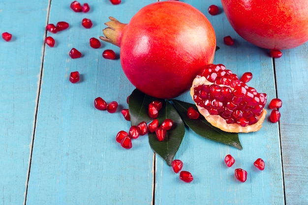 Photo ripe pomegranate fruits on the wooden background