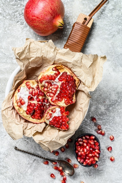 Ripe pomegranate and seeds on a wooden cutting Board. Organic fruit. 