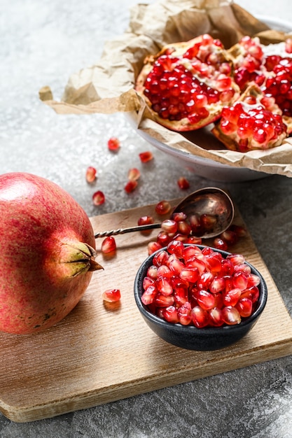 Ripe pomegranate and seeds on a wooden cutting Board.