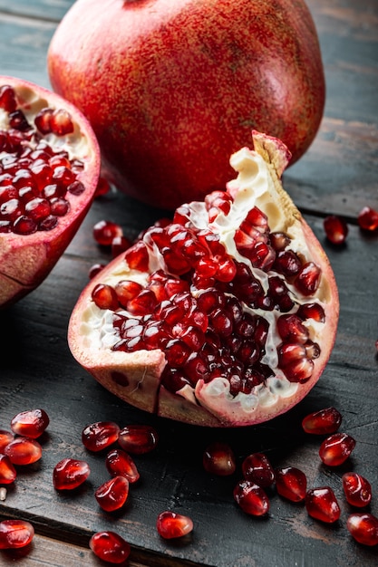 Ripe pomegranate with fresh juicy seeds, on old wooden table