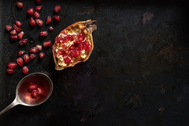 Ripe pomegranate with juicy fresh seeds in a spoon