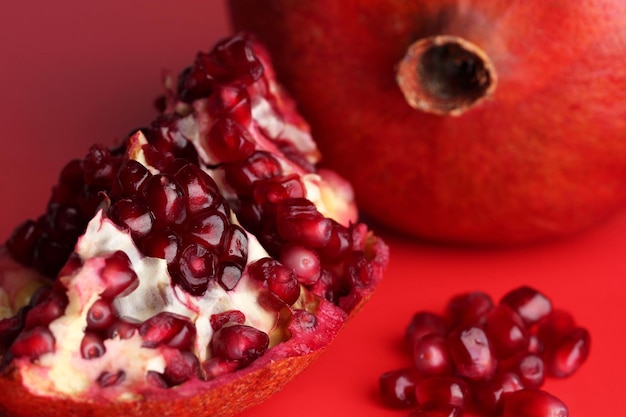 Ripe pomegranates on red background