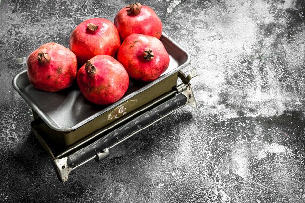 Ripe pomegranates on the scales on a rustic background