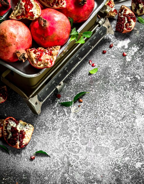 Ripe pomegranates on the scales on a rustic background