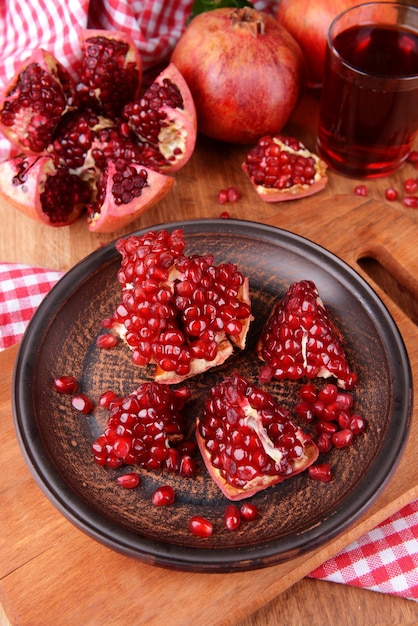 Ripe pomegranates with juice on table