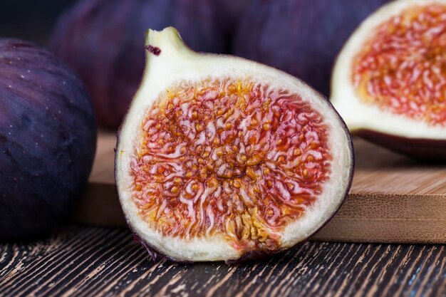 Ripe purple figs on a wooden table, ripe fig fruits with red pulp and lots of seeds