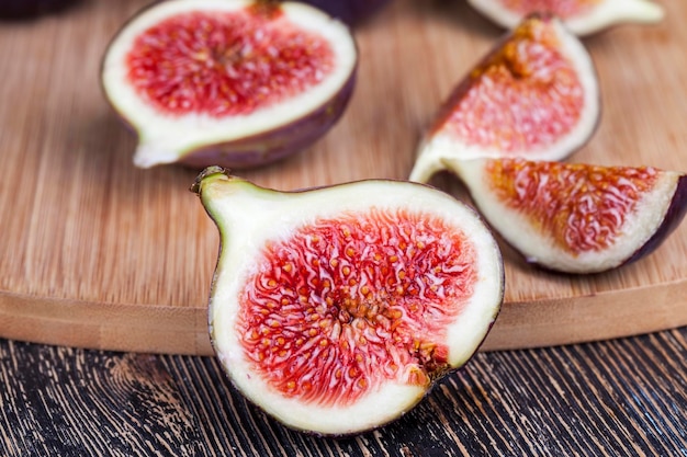 ripe purple figs on a wooden table, ripe fig fruits with red pulp and lots of seeds
