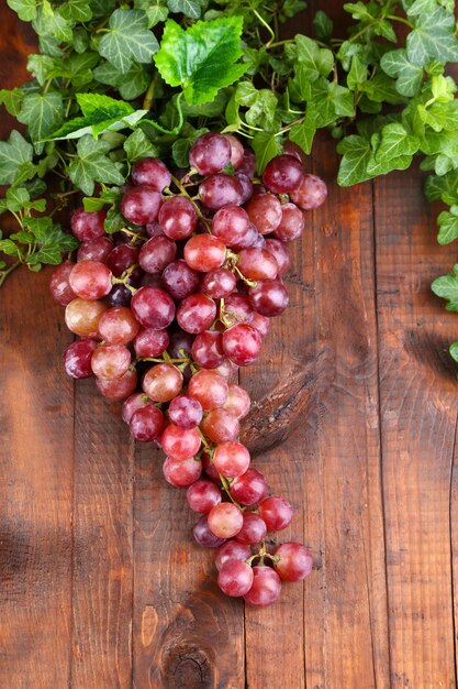 Ripe purple grapes on wooden table closeup