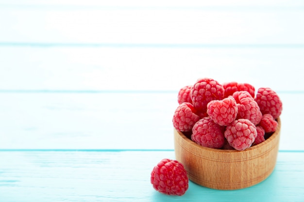 Ripe raspberries in a wooden bowl