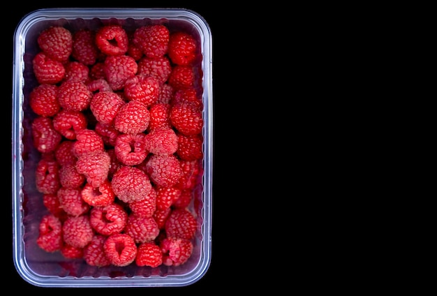 Ripe raspberries on wooden table with copyspace