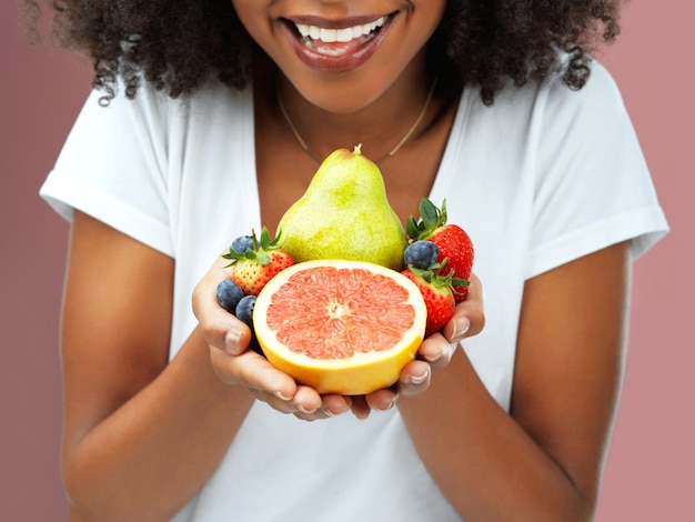 Ripe and ready to get in my belly Cropped studio shot of an young woman holding fruit against a pink background