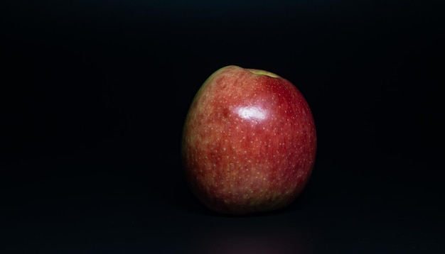 ripe red apple on black background