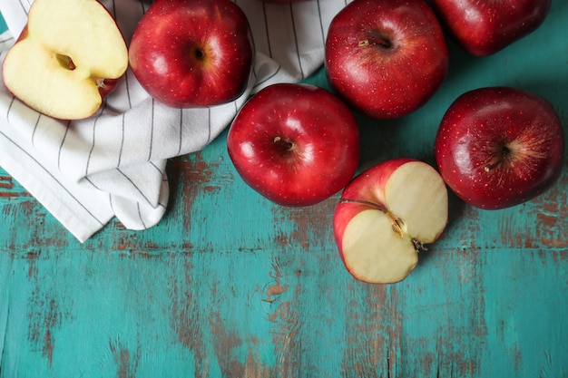 Ripe red apples on color wooden table