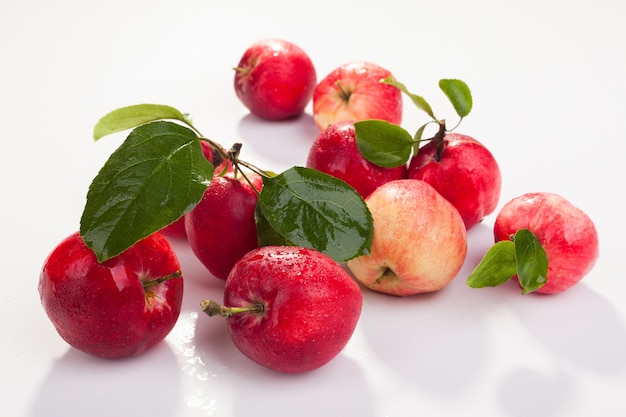 Ripe red apples with leaves and with dew drops on white Vegetarianism concept Closeup studio sho