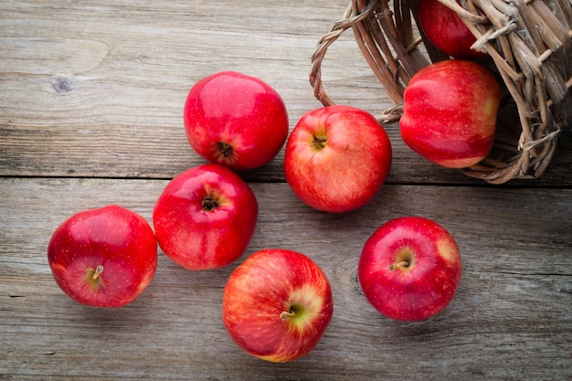 Ripe red apples on wooden background.