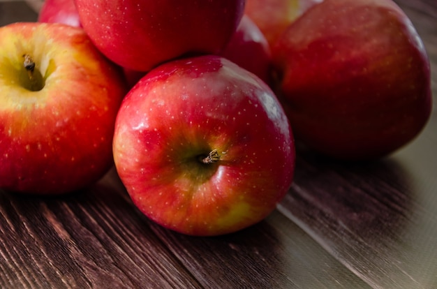 Mele rosse mature su uno sfondo di legno