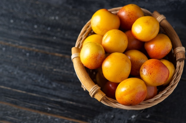 Ripe red apricots in a wooden basket