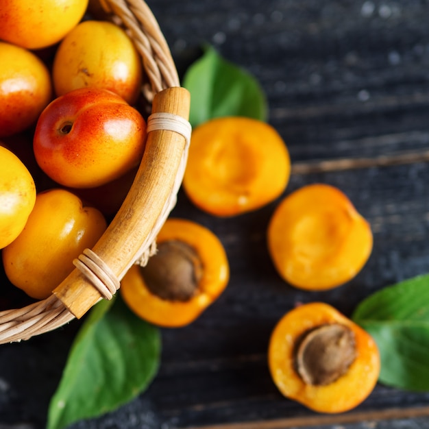 Ripe red apricots in a wooden basket