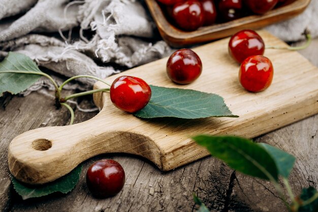 Ripe red cherries on a wooden table.