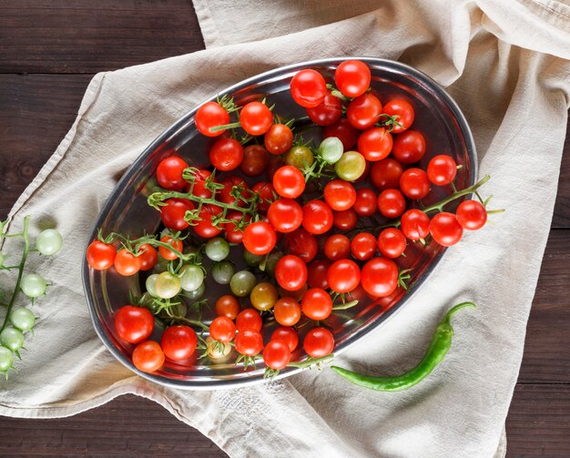 Foto pomodori ciliegia rossi maturi su un piatto di ferro