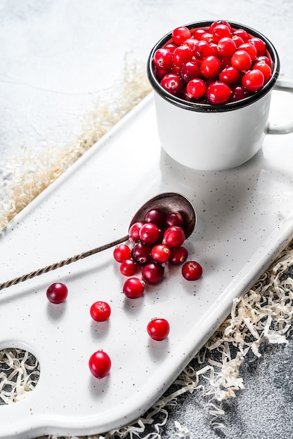 Ripe red cranberries in an iron mug. 