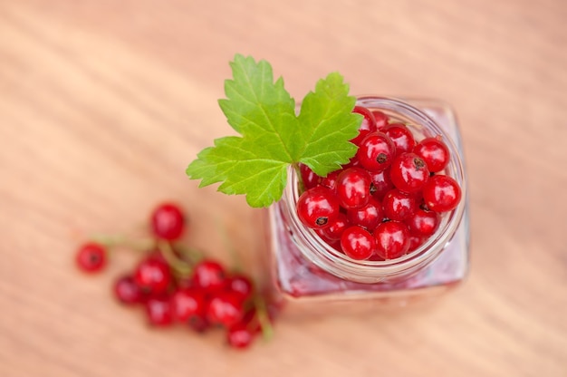 Ripe red currant berries on a neutral table background top view