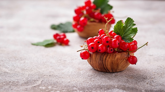 Ripe red currant berries in wooden bowls