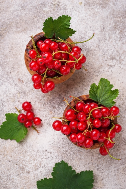 Ripe red currant berries in wooden bowls