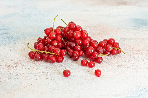 Ripe red currants on a light background. Fresh summer berries, healthy vitamins.