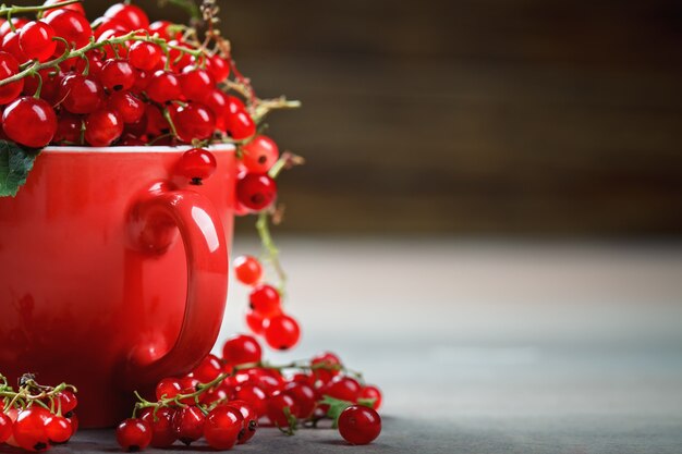 Ripe red currants on a wooden table.