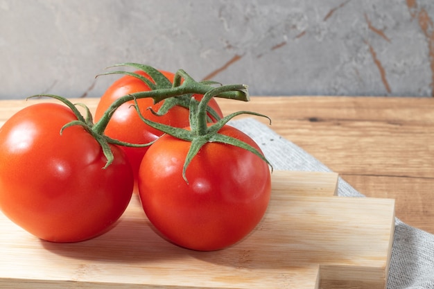 Pomodori olandesi rossi maturi sul tagliere.