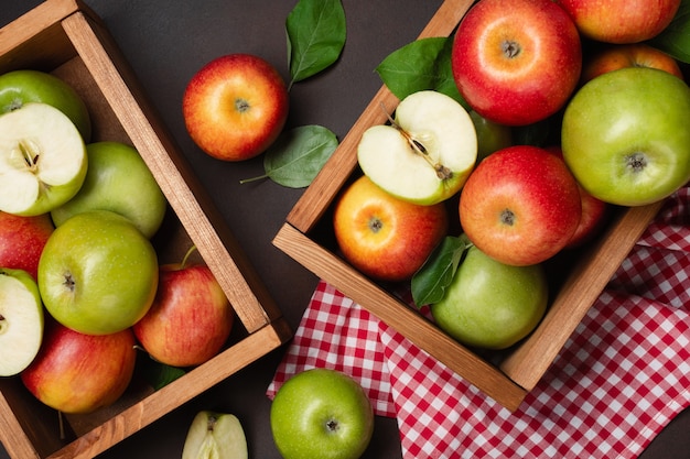 Ripe red and green apples in wooden box on a rusty background. Top view with space for your text.