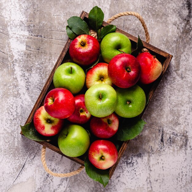 Ripe red and green apples in wooden box