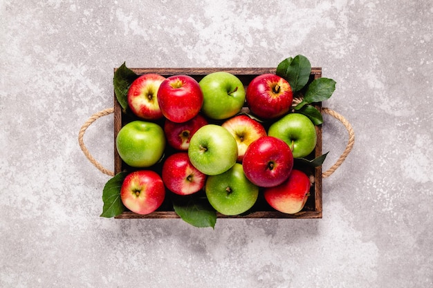 Ripe red and green apples in wooden box