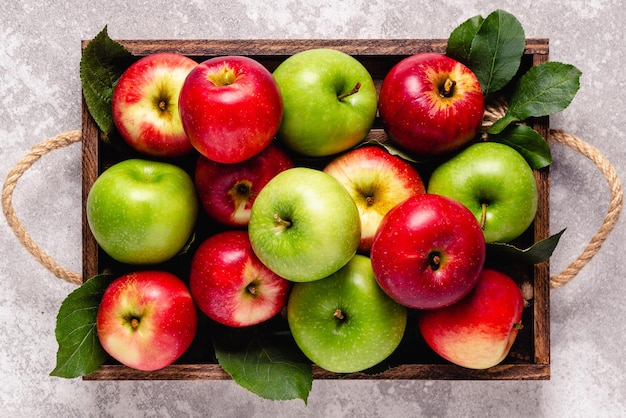 Ripe red and green apples in wooden box