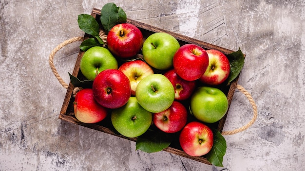 Ripe red and green apples in wooden box