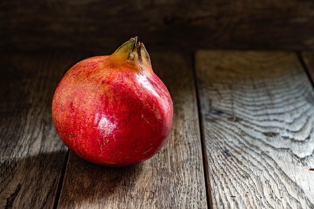 Photo ripe red pomegranate in on a wooden table