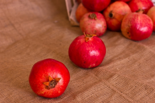 Ripe red pomegranates on a brown burlap